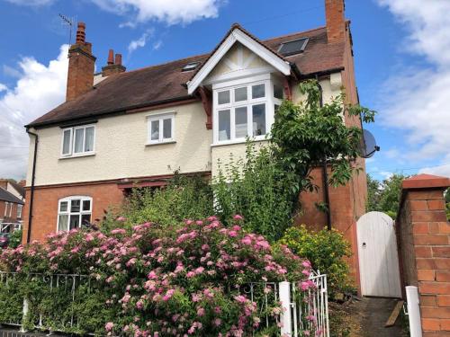 a house with pink flowers in front of it at Luxury 6 bedroom retreat in Stratford Upon Avon in Stratford-upon-Avon