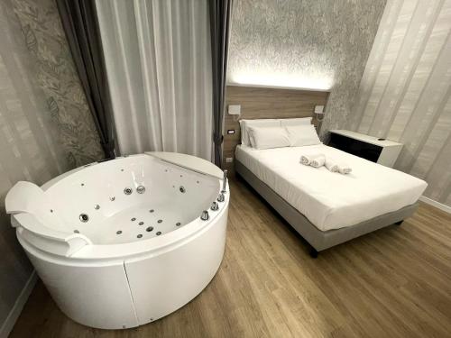 ROME'S GLORIA HOTEL في روما: غرفة نوم مع حوض استحمام بجانب سرير