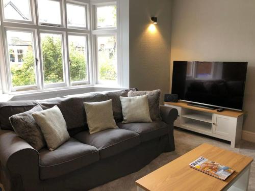 a living room with a couch and a flat screen tv at Luxury 6 bedroom retreat in Stratford Upon Avon in Stratford-upon-Avon