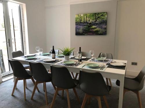 a dining room table with chairs and wine bottles at Luxury 6 bedroom retreat in Stratford Upon Avon in Stratford-upon-Avon
