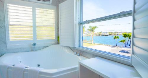 a white bathroom with a tub and a window at Devon Shores in Clearwater Beach