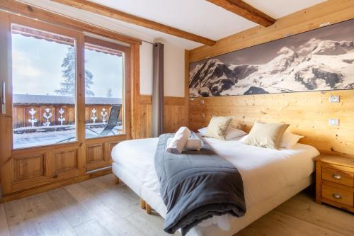 a bedroom with a bed and a large window at Chalet Lyskamm in Montvalezan