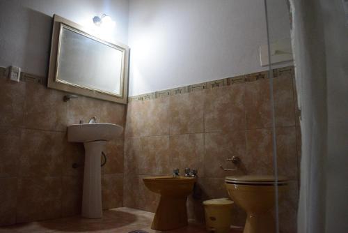 a bathroom with a sink and a toilet and a mirror at Casa en Cabalango in Cavalango