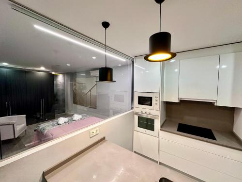 - une cuisine avec des placards blancs et un lit rose dans l'établissement Apartamento con vistas, Urb. Mijas golf., à Santa Fe de los Boliches
