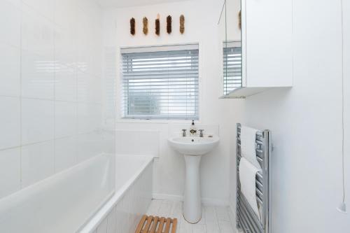 a white bathroom with a sink and a shower at Brett Stays - Middleton Oasis in Avonmouth