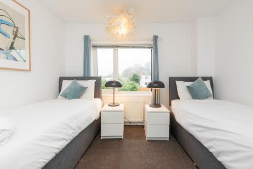 two twin beds in a room with a window at Brett Stays - Middleton Oasis in Avonmouth