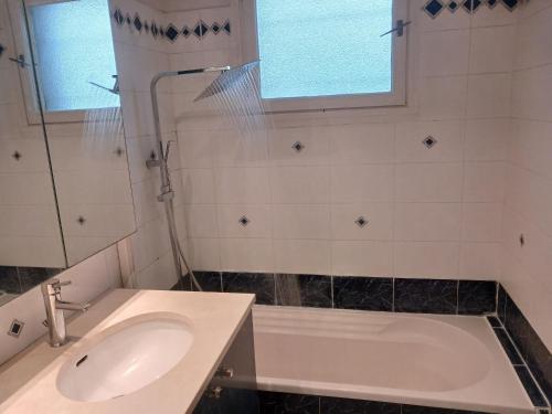 a bathroom with a sink and a tub and a window at PARADIS CHAMBRES D'HÔTES PROCHE PARIS - AÉROPORT CHARLES DE GAULLE AIRPORT - PARC DES EXPOSITION VILLEPINTE - DYSNAYLAND PARIS. in Tremblay En France