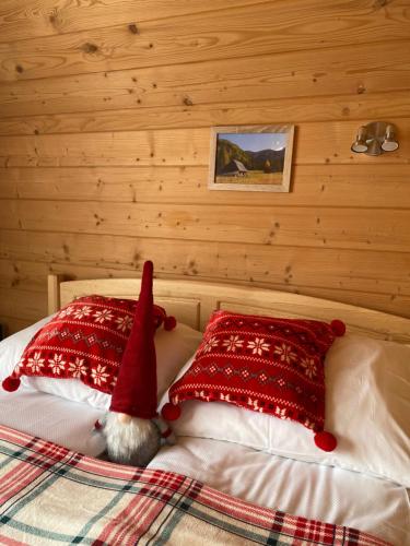 a santa hat sitting on a bed with two pillows at Domek JAWOR in Zakopane