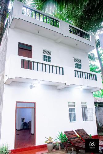 a white house with a balcony at BAWANS VILLA Holiday Home for Family or Group in Hikkaduwa