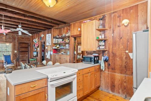 een keuken met houten wanden en een witte kookplaat bij Hildave Cottage 3 Bdrm Vacation Home in Pawleys Island