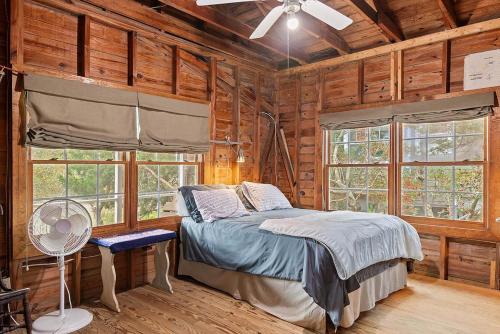 een slaapkamer met een bed in een blokhut bij Hildave Cottage 3 Bdrm Vacation Home in Pawleys Island
