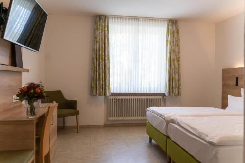 um quarto de hotel com uma cama e uma janela em Hotel Bergschlößchen em Simmern