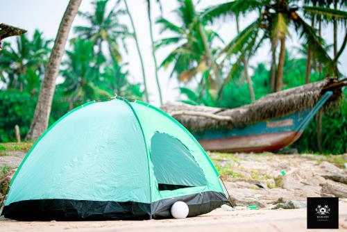 a green tent sitting on the ground next to a boat at BAWANS VILLA Holiday Home for Family or Group in Hikkaduwa