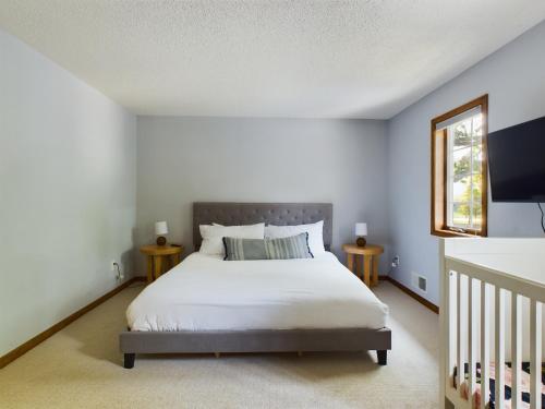 1 dormitorio con cama blanca y ventana en Hazeltine Hideaway, en Chaska