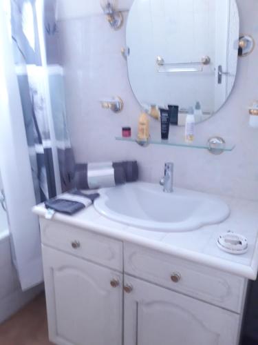 a bathroom with a white sink and a mirror at GITE EN PROVENCE in Istres