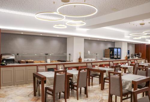 a restaurant with tables and chairs and a counter at Hotel São Bento da Porta Aberta & Spa in Geres