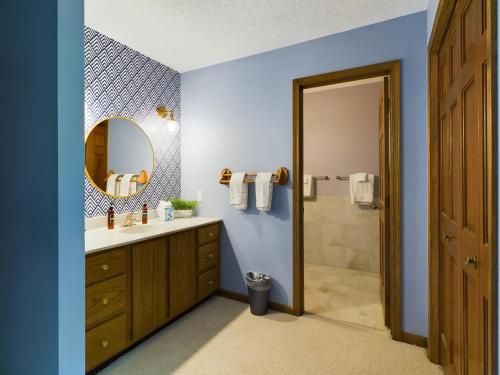 W łazience znajduje się umywalka i lustro. w obiekcie Hazeltine Hideaway w mieście Chaska