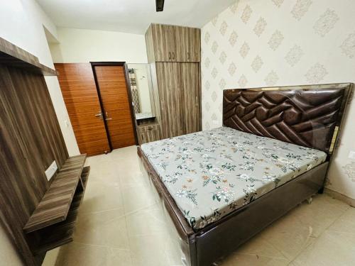 Habitación pequeña con cama y puerta de madera en Mona city homes en Kharar