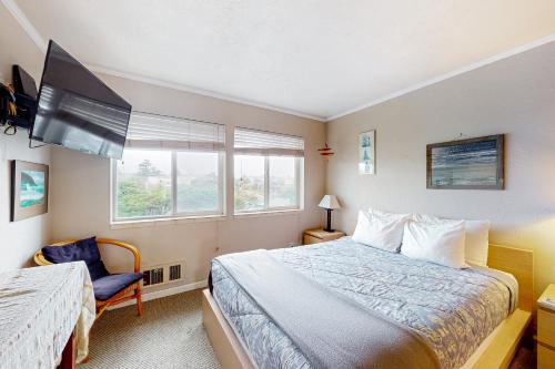 a bedroom with a bed and a tv and a chair at The Big View in Newport