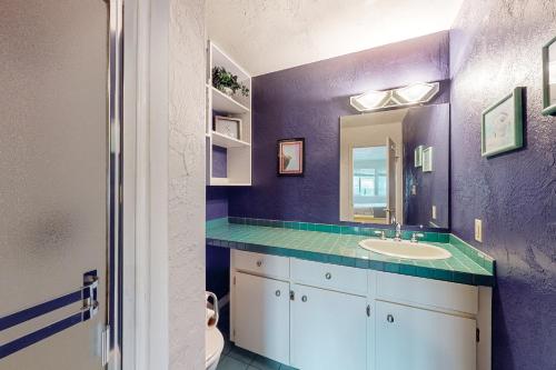 a purple bathroom with a sink and a mirror at The Big View in Newport