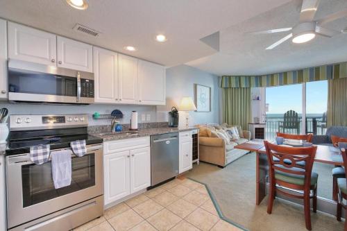 a kitchen with white cabinets and a living room at 2501 S Ocean Blvd, 1127 - Ocean View Sleeps 6 in Myrtle Beach