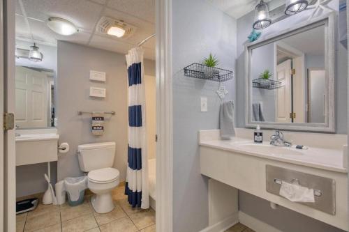 a bathroom with a sink and a toilet and a mirror at 2501 S Ocean Blvd, 1127 - Ocean View Sleeps 6 in Myrtle Beach