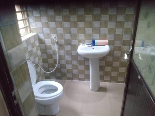 uma casa de banho com um WC e um lavatório em 2 bedroom service apartment with full services em Idimu