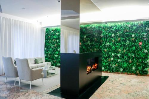 a living room with a fireplace and a green wall at Hotel São Bento da Porta Aberta & Spa in Geres