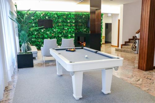 a pool table in a room with a wall of plants at Hotel São Bento da Porta Aberta & Spa in Geres