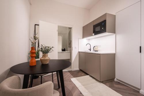 eine Küche und ein Esszimmer mit einem Tisch und einem Waschbecken in der Unterkunft A13- Deluxe Apartments, Best Location, by BQA in Budapest