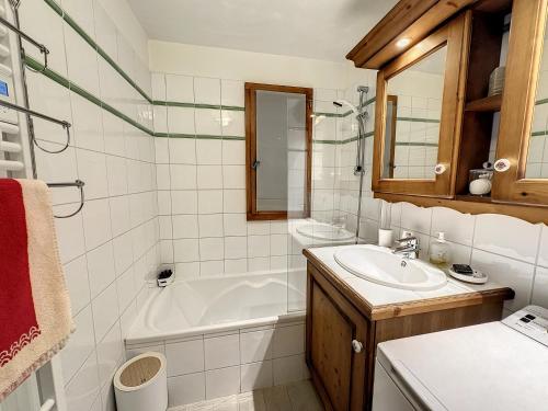 une salle de bain avec une baignoire et un lavabo et une baignoire dans l'établissement Grey Squirrel Home, à Chamonix-Mont-Blanc