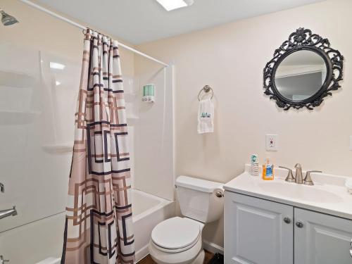 un bagno con un water, un lavandino e uno specchio di Chardonnay Cottage - GOTL Strip - Cozy & Quaint a Geneva
