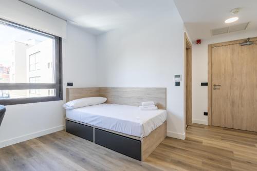 1 dormitorio con cama y ventana grande en micampus Wynwood - Tovar en Madrid