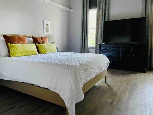 a bedroom with a bed and a flat screen tv at Suite Home Indiana Apartments in Evansville