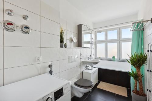 a white bathroom with a toilet and a sink at *NulandtApartment* #2 in Merseburg