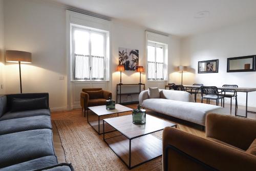 una sala de estar con sofás, mesas y ventanas en Adelaide Elegant apartments en Milán