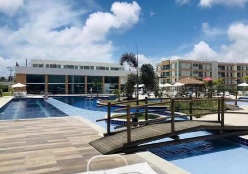 ein Resort mit einem Swimmingpool und einem Gebäude in der Unterkunft Muro Alto Condomínio Clube – Flats completos para a família por Yolo in Ipojuca