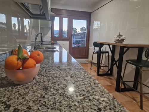 een keuken met een kom sinaasappels op een aanrecht bij La casa del patio in Zafra