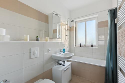 a bathroom with a sink and a toilet and a tub at Aura - Nula #1 -2 Zimmer, 4 Betten, Küche, Balkon, Waschmaschine in Merseburg