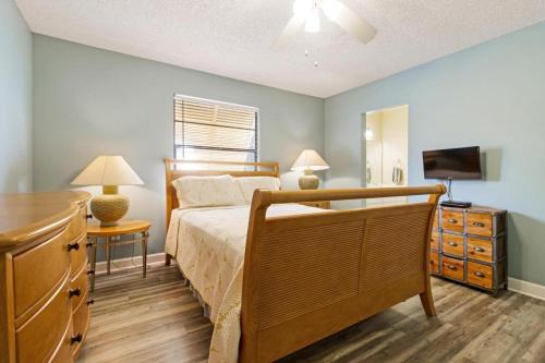 a bedroom with a bed and a dresser with a television at Mangoes on Magnolia in Anna Maria