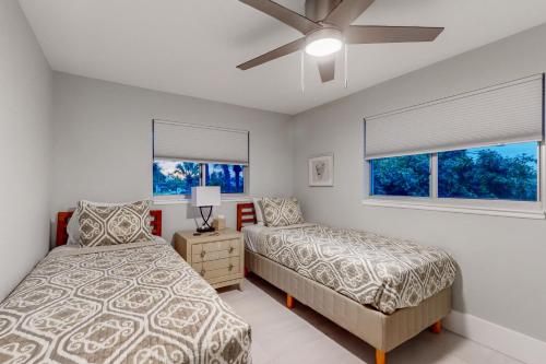 a bedroom with two beds and a ceiling fan at Gather Together - Unit 143 in Marco Island