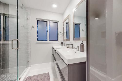 a white bathroom with a sink and a shower at Gather Together - Unit 143 in Marco Island
