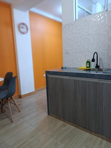 a kitchen with a counter with a sink and a chair at Departamento PET Friendly in Chancay
