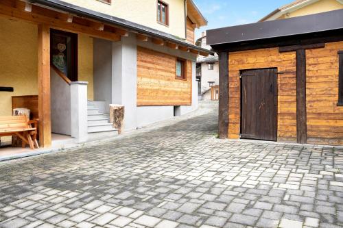a cobblestone street next to a building with a door at Chalet Provenzale Trilocale in Acceglio