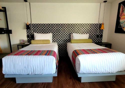 two beds sitting next to each other in a room at Estancias VIVE MX cuauhtémoc in Mexico City