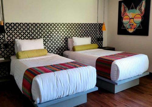 two beds sitting next to each other in a room at Estancias VIVE MX cuauhtémoc in Mexico City