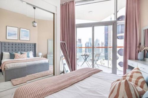 una camera con un letto e una grande finestra in vetro di Marasi Moods 2BD on Burj Khalifa and Canal views a Dubai