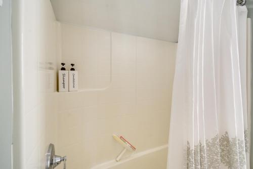 a white bathroom with a tub and a shower curtain at Oceanfront Moclips Retreat with Beach Access and View! in Moclips
