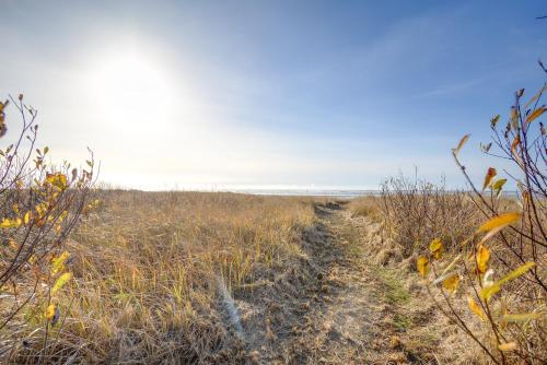 a dirt path through a field with the ocean in the background at Oceanfront Moclips Retreat with Beach Access and View! in Moclips