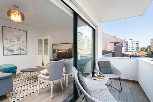 a living room with a balcony with chairs and a tv at Host Wise - Elegant Spacious Flat w Balcony - Ace Location in Vila Nova de Gaia